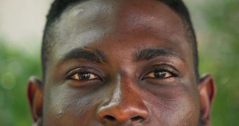Close-Up Portrait of African American Man Examining Skin Outdoors