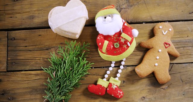Christmas-themed items on a rustic wooden table create a warm and festive atmosphere. Perfect for use in holiday marketing materials, greeting cards, seasonal blog posts, and social media content to evoke a cozy and joyful holiday spirit.