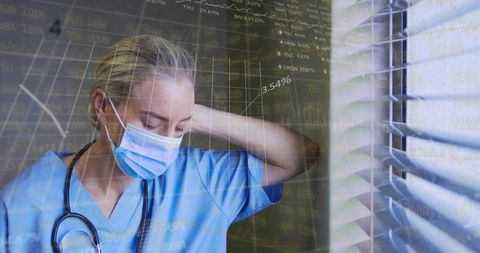 Nurse rubbing neck by window wearing mask and stethoscope with medical data overlay