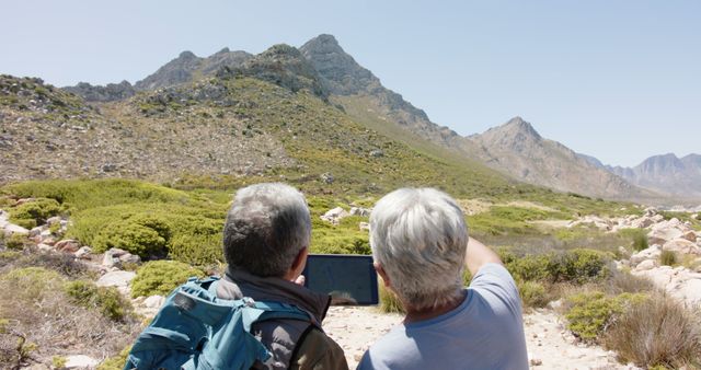 Senior Hikers Using Tablet to Navigate Mountainous Terrain - Download Free Stock Images Pikwizard.com