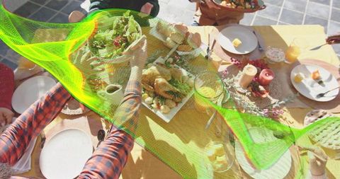Friends Reaching for Roast Chicken and Fresh Salad on Sunlit Outdoor Dining Table