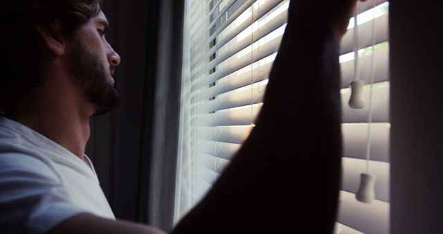 Pensive Man Looking Through Window Blinds - Download Free Stock Images Pikwizard.com