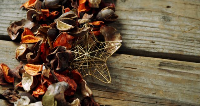 Dry autumn leaves and a decorative gold star are arranged on a rustic wooden surface, creating a cozy and natural autumn atmosphere. Perfect for seasonal greeting cards, holiday invitations, or autumn-inspired home decor and craft ideas.