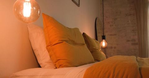 Warm bedroom interior with mustard yellow bedding and exposed brick wall