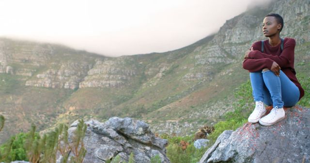 Thoughtful Young Woman Sitting on Rock in Mountain Landscape - Download Free Stock Images Pikwizard.com