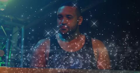 Keyboardist performing soulful grooves with blue-green stage lights and sparkling bokeh
