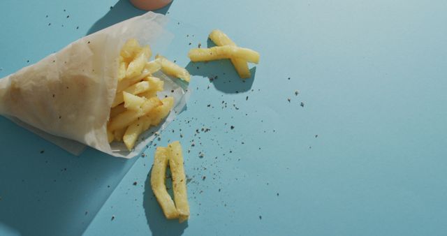 Salted French fries scattered on blue background - Download Free Stock Images Pikwizard.com