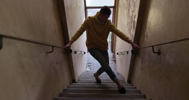 Caucasian male dancer dancing in abandoned staircase, copy space. Dance, urban lifestyle and movement, unaltered.