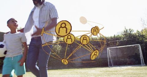Father and son walking on soccer field holding ball with network connection overlay