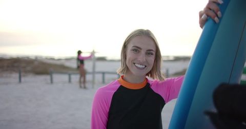 Smiling Young Woman Holding Surfboard on Sunny Beach