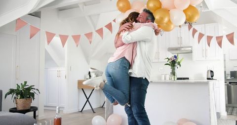 Joyful engagement celebration at home with balloons