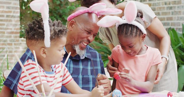 Multi-generational family enjoying Easter craft activities outdoors. Perfect for illustrating family bonding, holiday celebrations, joyful outdoor activities, and creativity. Suitable for Easter-themed promotions, holiday cards, and family-centric content.
