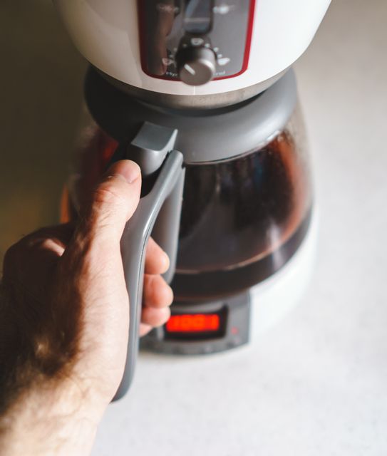 Hand Pouring Coffee from Electric Coffee Maker - Download Free Stock Images Pikwizard.com