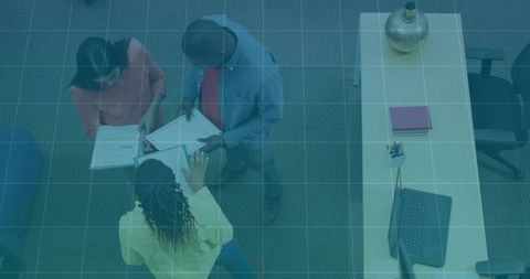 Coworkers discussing documents in modern office workspace