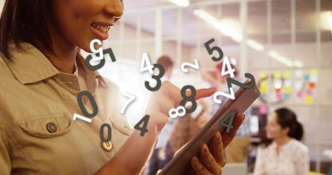 Woman tapping tablet with floating analytics overlay, collaborating in modern office