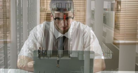 Businessman Using Laptop with Overlay of Colleagues and Glass Offices