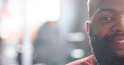 Smiling african man closeup with beard and warm backlight, headshot with bokeh