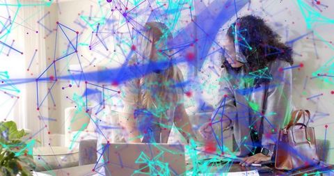 Collaborating women leaning over laptop with blazer and headset, ar data network overlay