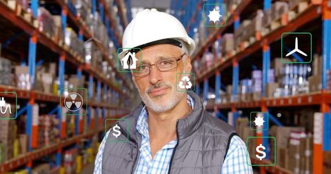 Warehouse supervisor with safety helm displays energy efficiency icons