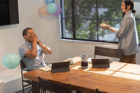 Surprised Coworker Receiving Birthday Cake in Office Meeting