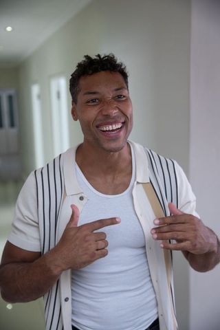 Smiling African American Man in Hallway Pointing at Himself