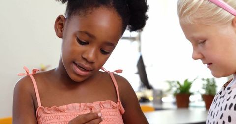 African american girl and caucasian friend playing with crafts