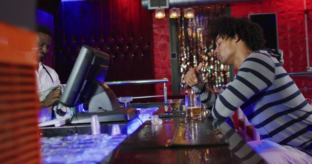 Image of smiling african american barman and drunk man sitting drinking beer at the bar - Download Free Stock Photos Pikwizard.com