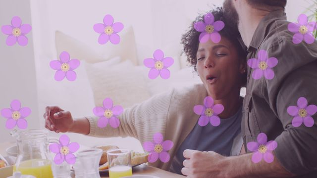 Cheerful diverse couple spending morning together while having breakfast, overlaid with animated flowers. Perfect for concepts related to love, romance, happy relationships, and cheerful domestic life. Useful for ads, social media posts, and websites focusing on lifestyle, relationships, and celebratory moments.