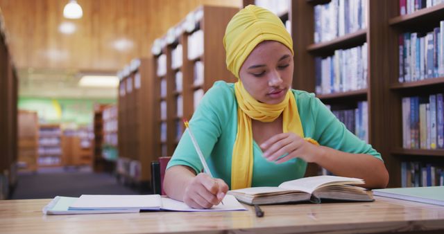 Focused Student Studying in Library, Writing Notes in Notebook - Download Free Stock Images Pikwizard.com