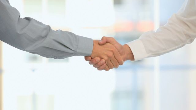 Two individuals shaking hands, symbolizing an agreement or partnership. Ideal for illustrating concepts related to business deals, successful negotiations, and professional cooperation. Can be used in business websites, blogs about corporate culture, or professional networking articles.