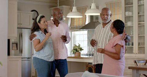 Senior Friends Celebrating and Enjoying Drinks Together at Home