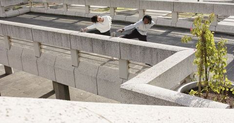 Urban duo stretching on concrete ramp practicing flexibility and outdoor fitness