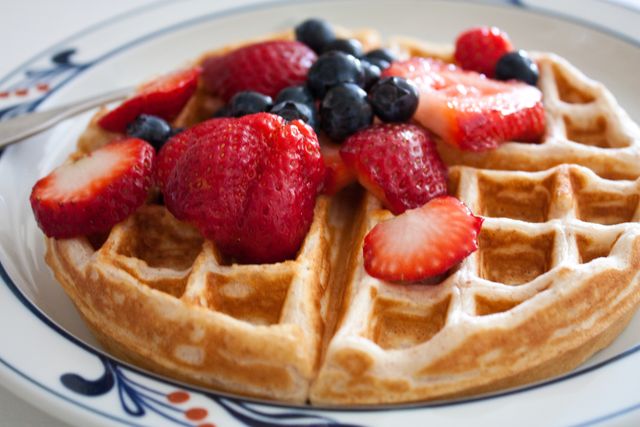 Delicious breakfast waffles drizzled with fresh strawberries and blueberries. Ideal for food blogs, culinary websites, restaurant menus, and social media content focused on breakfast and brunch. Can also be used in advertisements for cafes, recipe books, and nutrition guides.