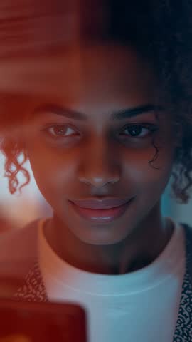 Young woman reading smartphone message and smiling in cozy home lounge vertical video