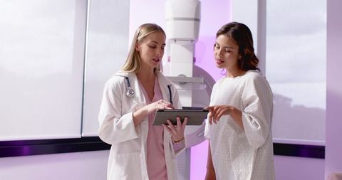 Doctor Consulting Patient Over Mammogram Results on Tablet in Breast Imaging Clinic