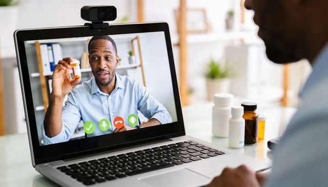 Clinician holding prescription bottle, explaining medication during telehealth consultation