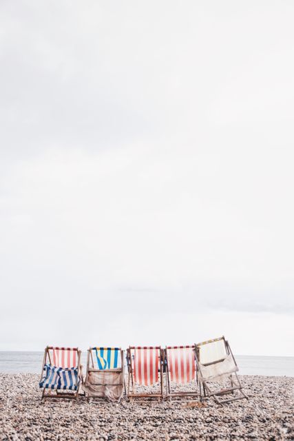 Colorful Deck Chairs on a Pebble Beach Under Clear Sky - Download Free Stock Images Pikwizard.com