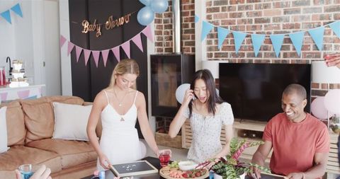 Friends Celebrating Baby Shower in Festive Living Room Setting