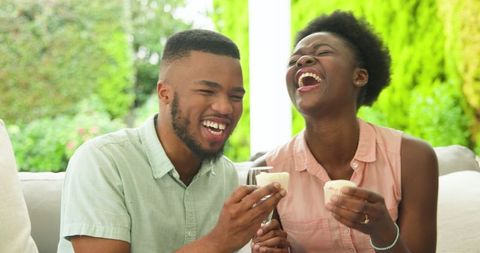 Joyful Couple Sharing Laughs While Toasting Outdoors