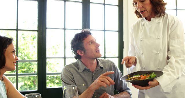 Chef Discussing Dish with Restaurant Customers in Bright Setting - Download Free Stock Images Pikwizard.com