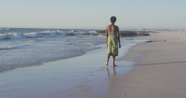 Solitary Woman Walking Along Sandy Beach at Sunset - Download Free Stock Images Pikwizard.com