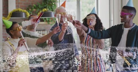 Toasting friends in party hats and novelty shades, raising champagne flutes at home