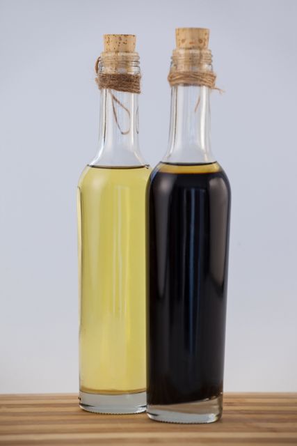 Olive oil in bottles on wooden table against wall