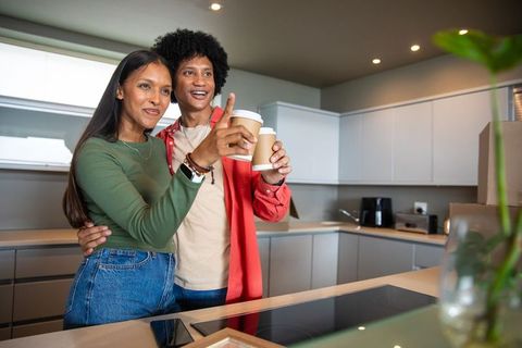 Couple Enjoying Beverages in Modern Kitchen with Smiling Expression