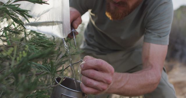 Close-Up of Survivalist Collecting Water From a Makeshift Camp Filter - Download Free Stock Images Pikwizard.com