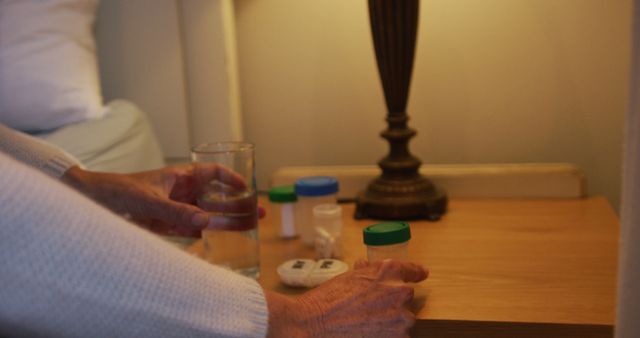 Elderly Person Organizing Medication in Bedroom with Bedside Lamp On - Download Free Stock Images Pikwizard.com