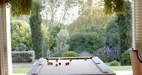 Billiard Table with View of Serene Garden Through Opened Blinds