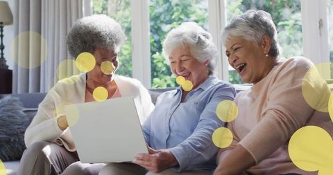 Senior Women Having Fun with Laptop at Home Surrounded by Digital Effects