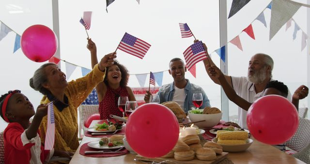 Multi-generational American family celebrating national holiday at dining table with American flags and festive red, white, and blue decor. Great for illustrating family bonds, patriotic celebrations, holiday meals, and diverse family gatherings.