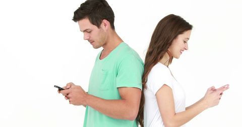 Back-to-back young adults engrossed in smartphones